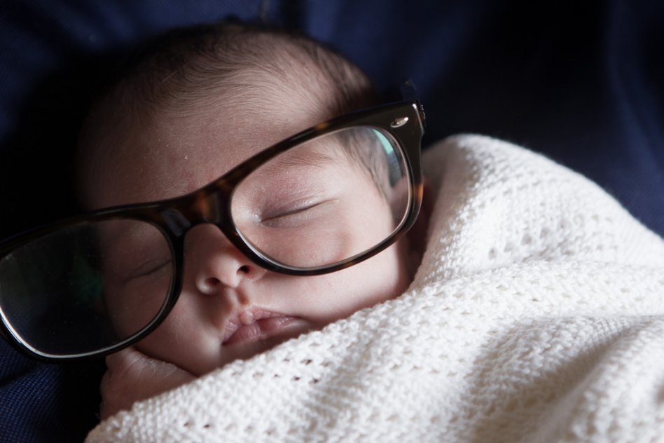 portrait of newborn baby wearing mother's spectacles